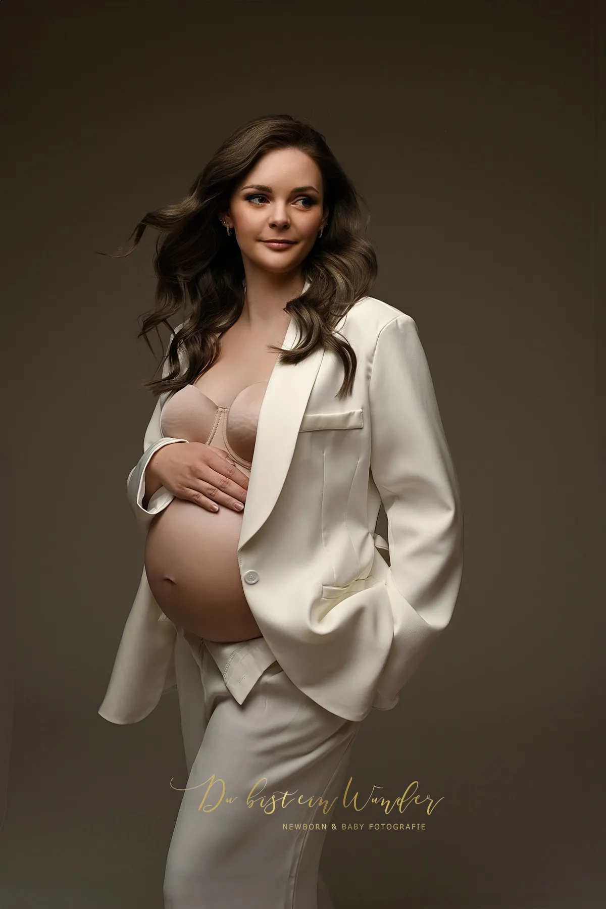 Sommer Babybauch Shooting auf Blumenwiese im orangefarbenen Kleid