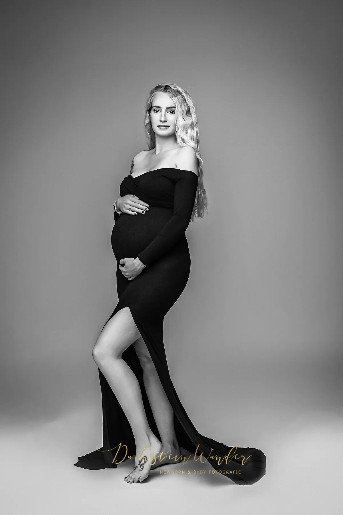 Elegantes Babybauch Portrait im beigen Rüschenkleid vor dunklem Hintergrund
