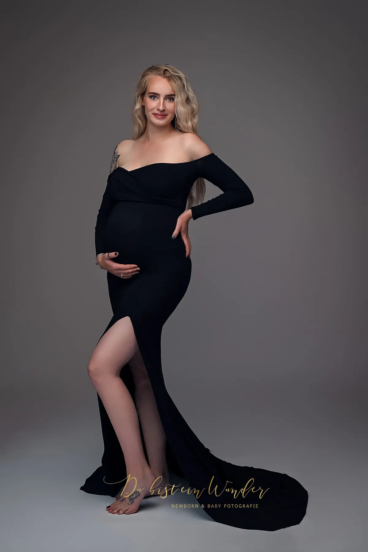 Babybauch Shooting mit Engelsflügeln und Krone im hellen Studio