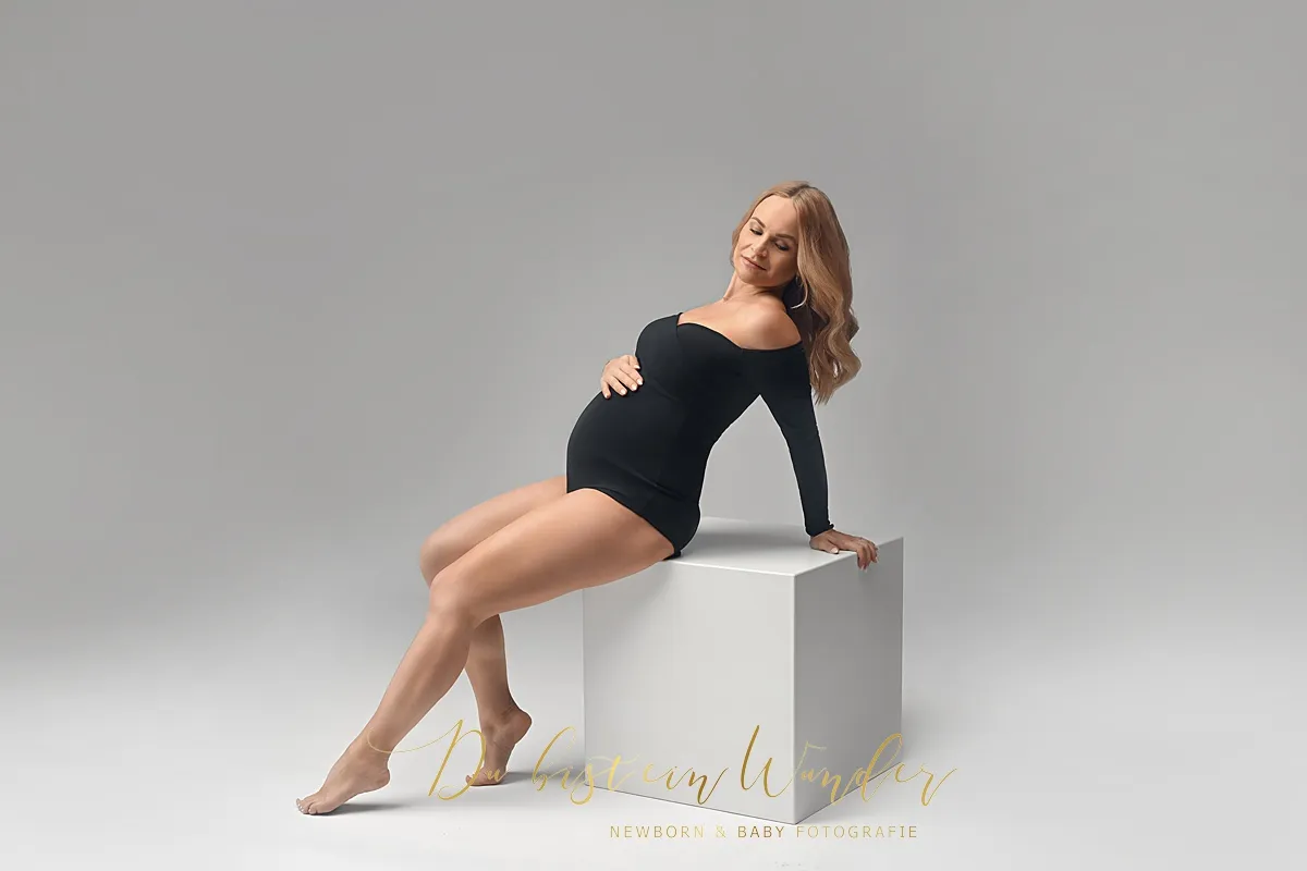 Babybauch Fotografie im weißen Spitzenkleid mit Schleier und Krone im Studio