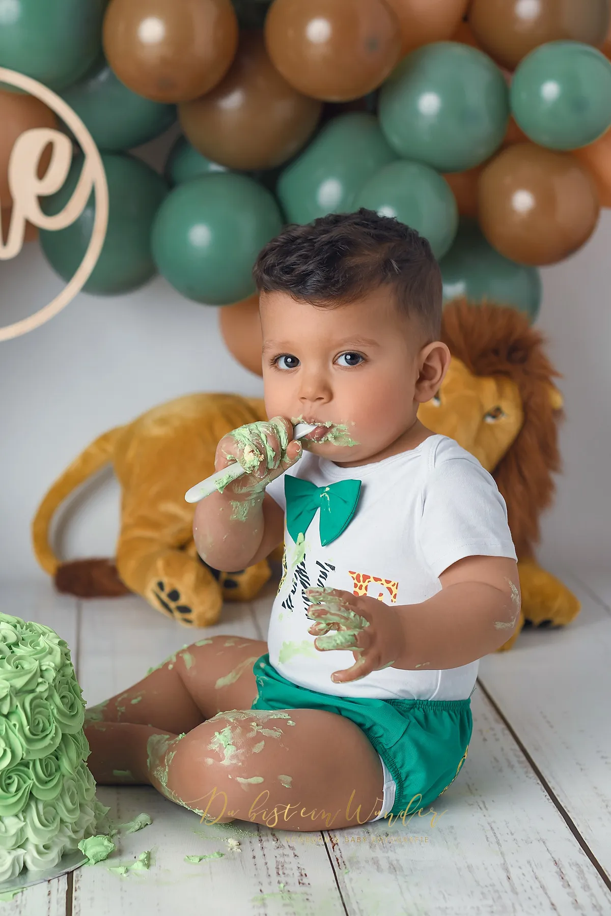 Junge mit cremiger Torte beim Blau-Gold Cake Smash