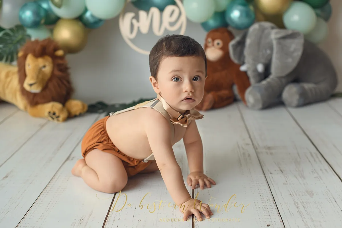 Junge im weißen Strampler beim Boho Cake Smash