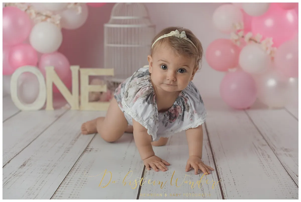 Stehender Junge mit grünen Ballons
