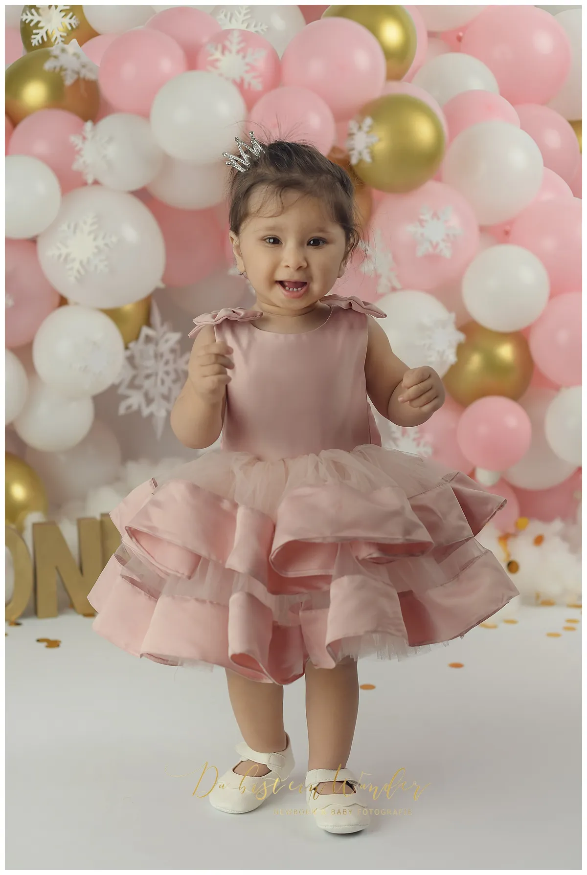 Mädchen mit Blumenkranz in rosa Badewanne nach dem Cake Smash