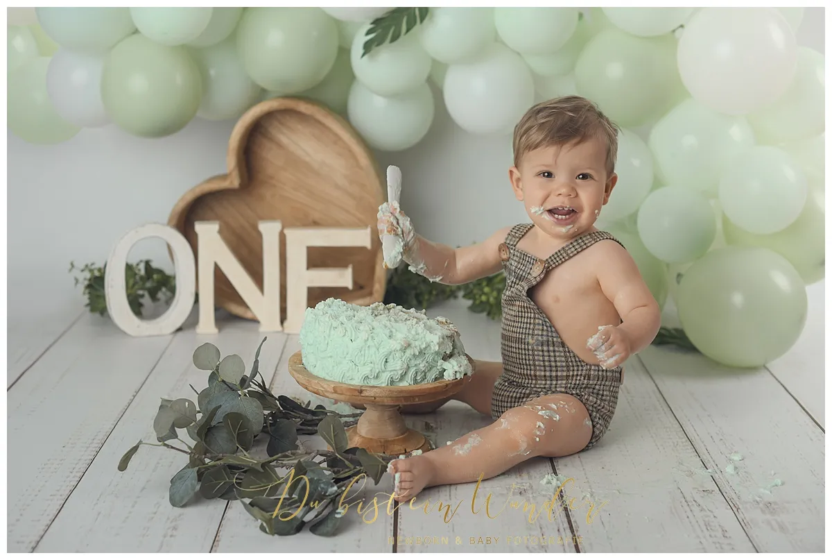 Mädchen greift nach rosa Torte beim Cake Smash Shooting