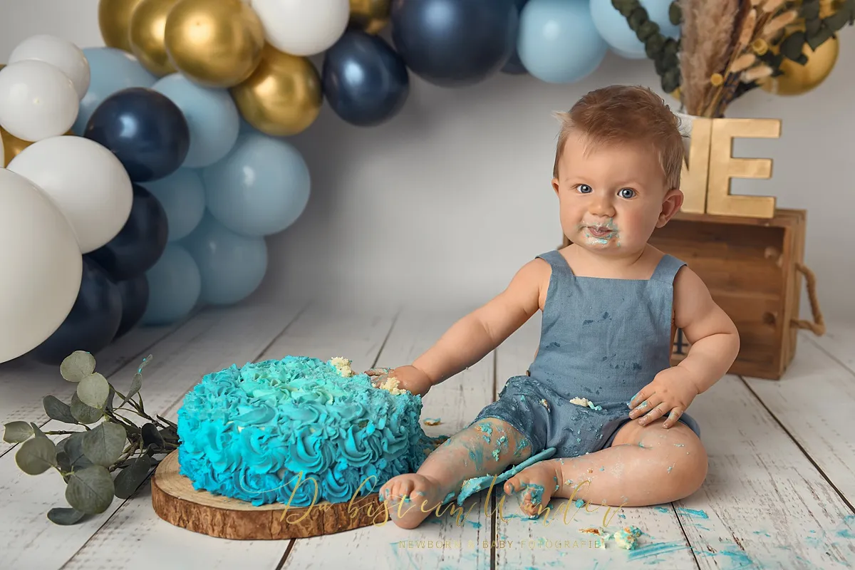 Junge mit matschiger Torte beim Blau-Gold Shooting
