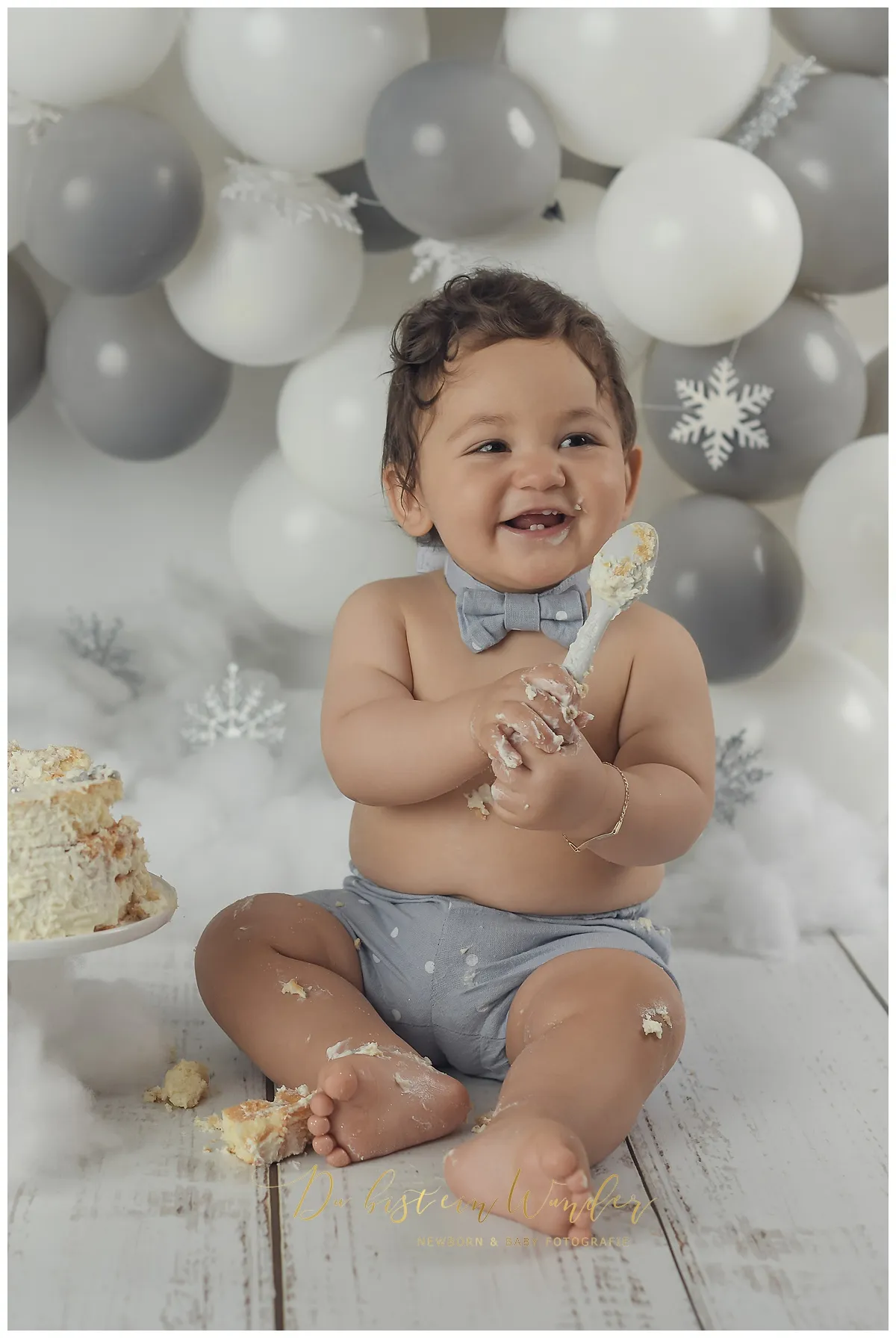 Lachender Junge mit grünen Ballons beim Cake-Smash Shooting zum ersten Geburtstag