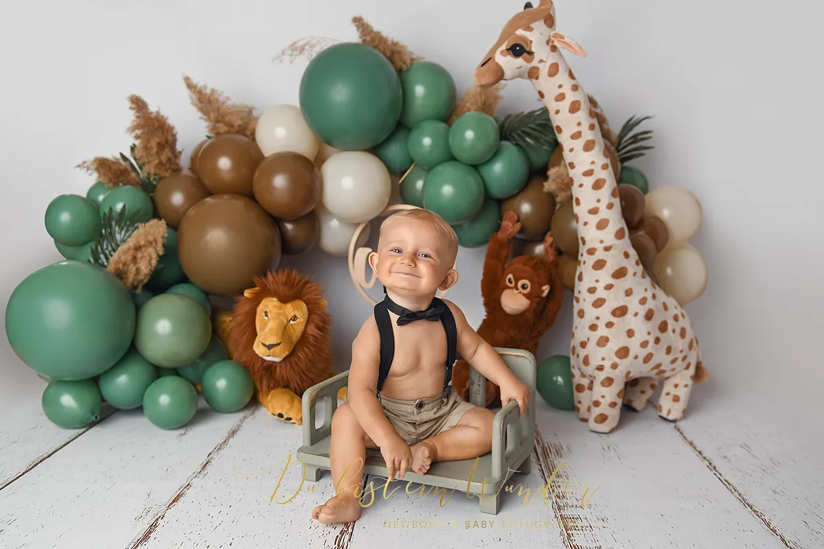 Junge mit Fliege und grünen Ballons beim Safari Cake Smash
