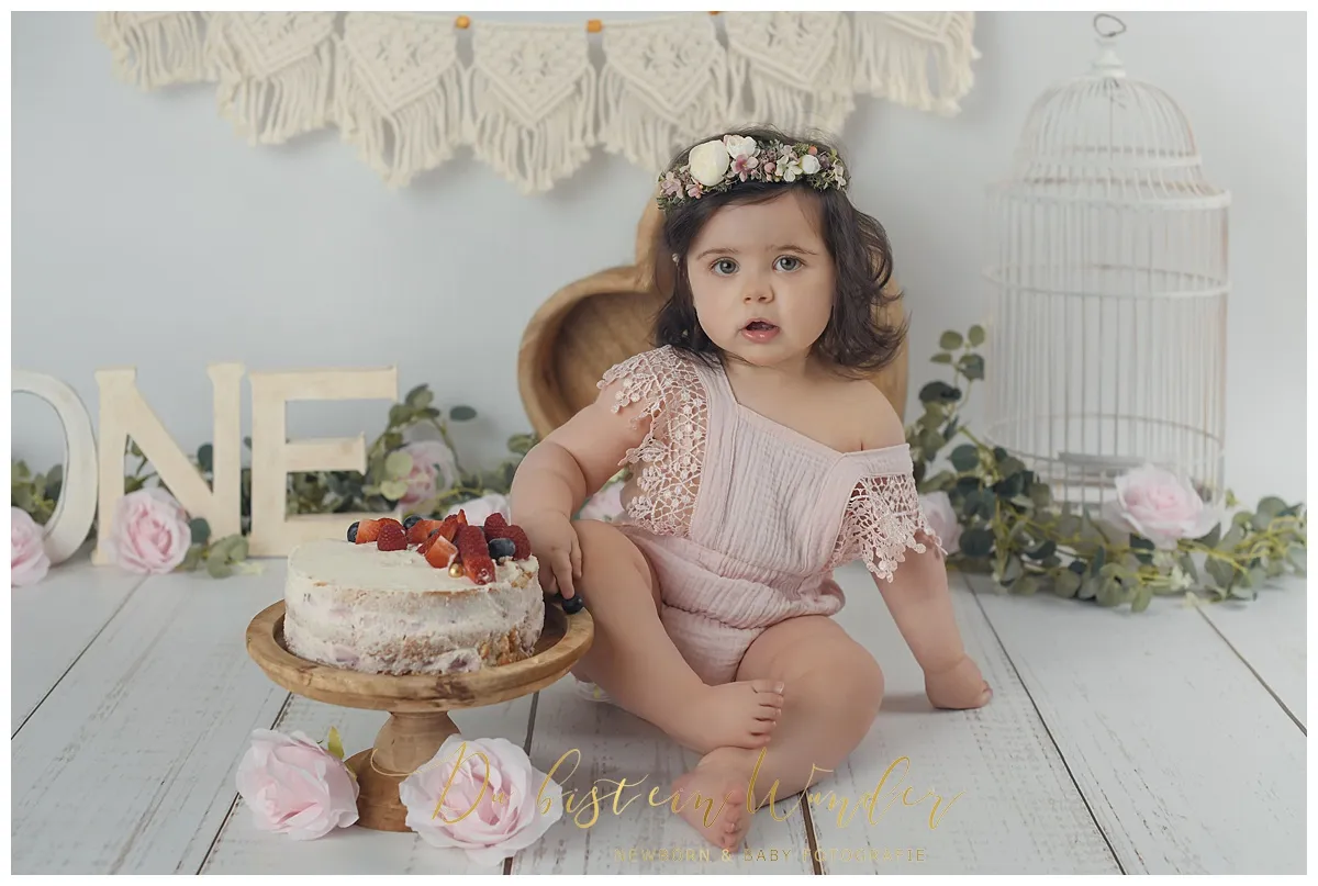 Mädchen mit ONE Buchstaben beim rosa Geburtstagsshooting