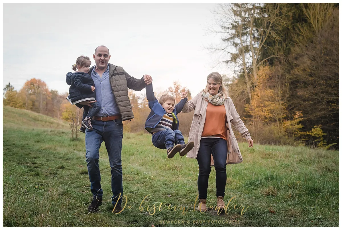 Kind schwingt im Herbst beim Familien Fotoshooting