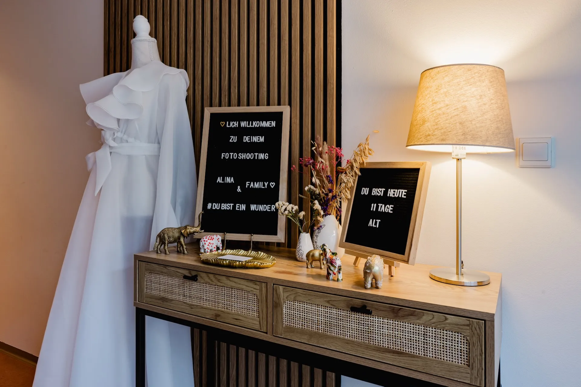 Empfangsbereich mit Willkommens-Letterboard und Babybauch-Kleid im Fotostudio Altdorf