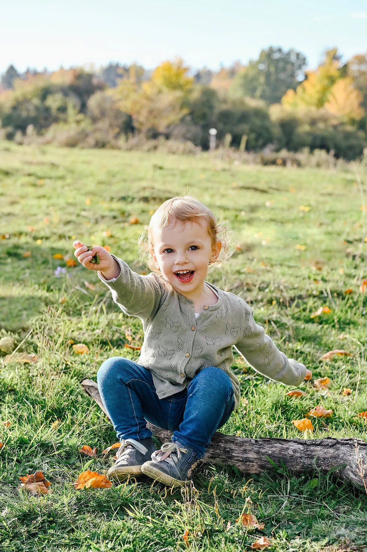 Kind auf Holzstamm Kinder-Fotoshooting