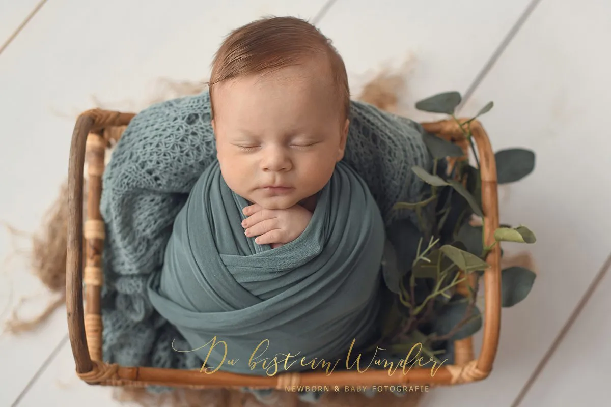 Friedliches Baby im weißen Strickbett