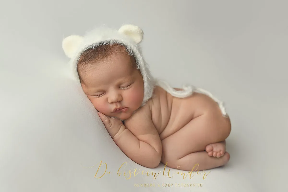 Babyhändchen auf weißer Decke