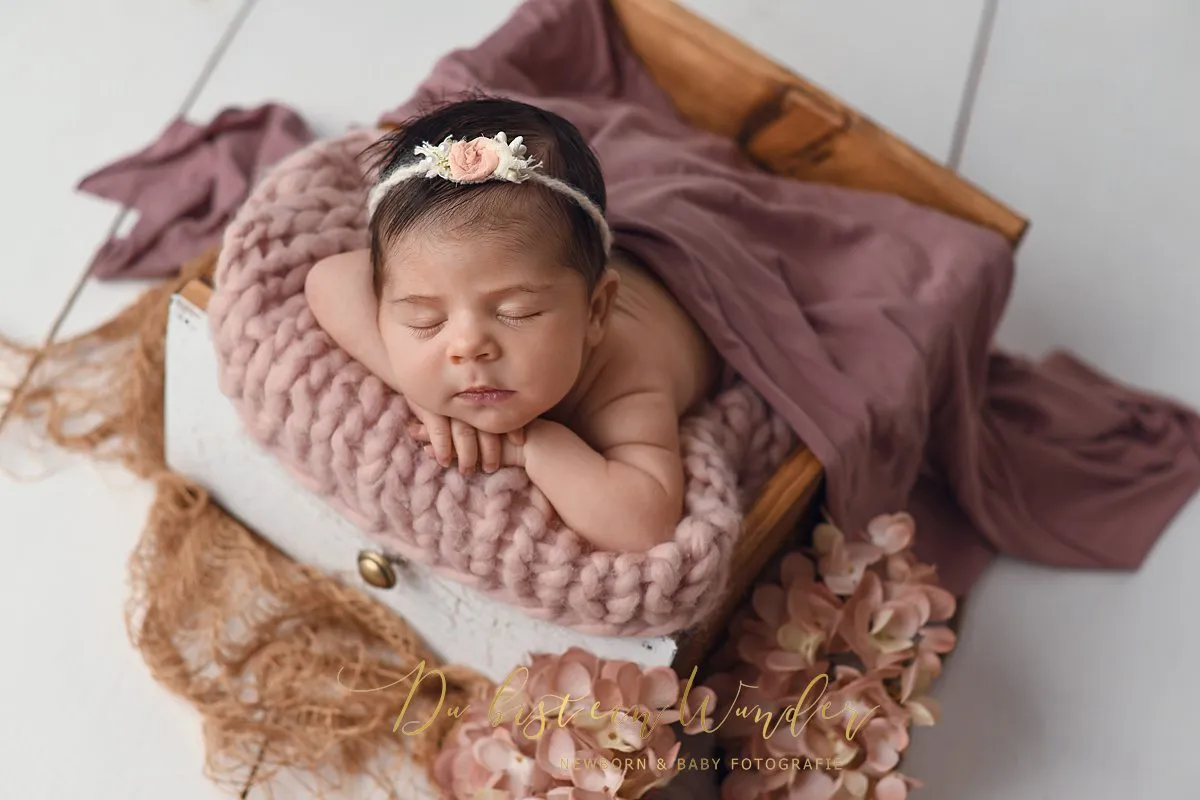 Newborn Portrait im hellen Korb mit Blumen
