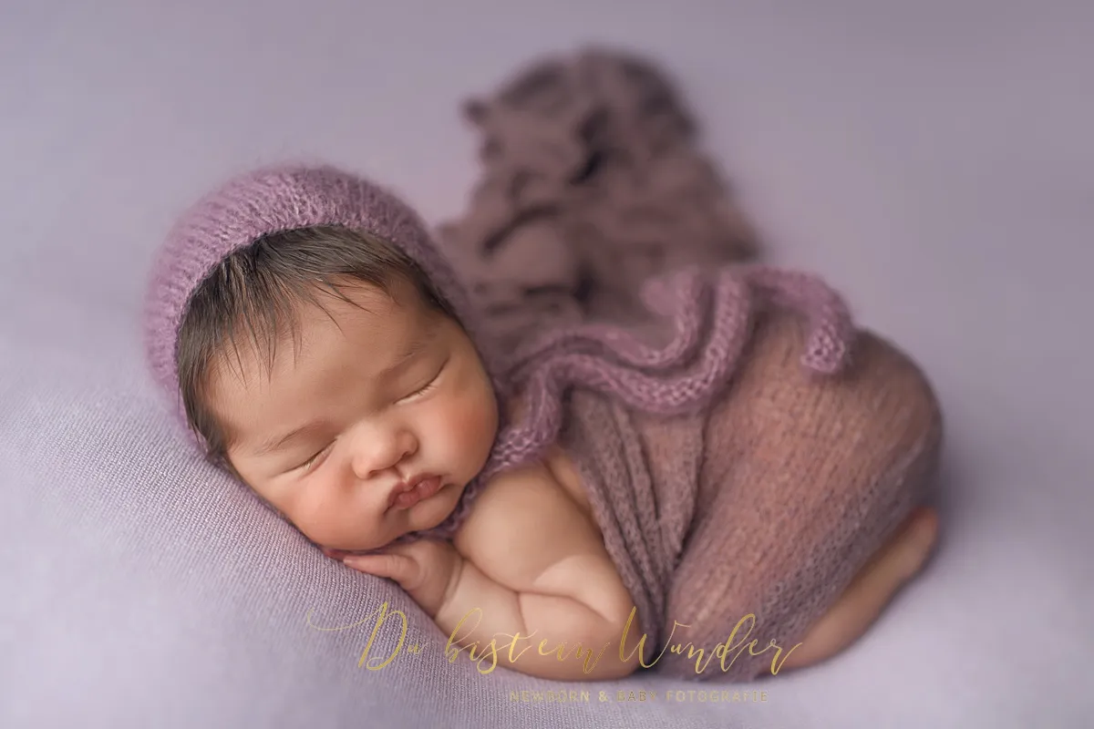 Neugeborenes Baby in lila Strickoutfit mit Mütze beim Newborn Shooting in Altdorf bei Nürnberg
