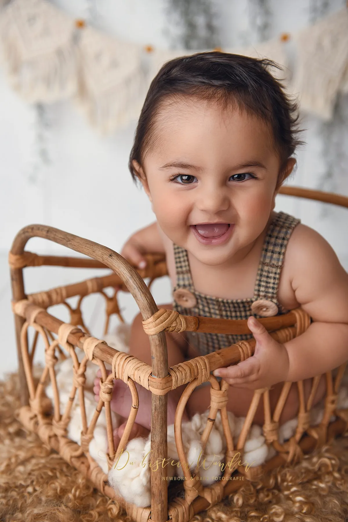 Lächelndes Baby im Rattanbett