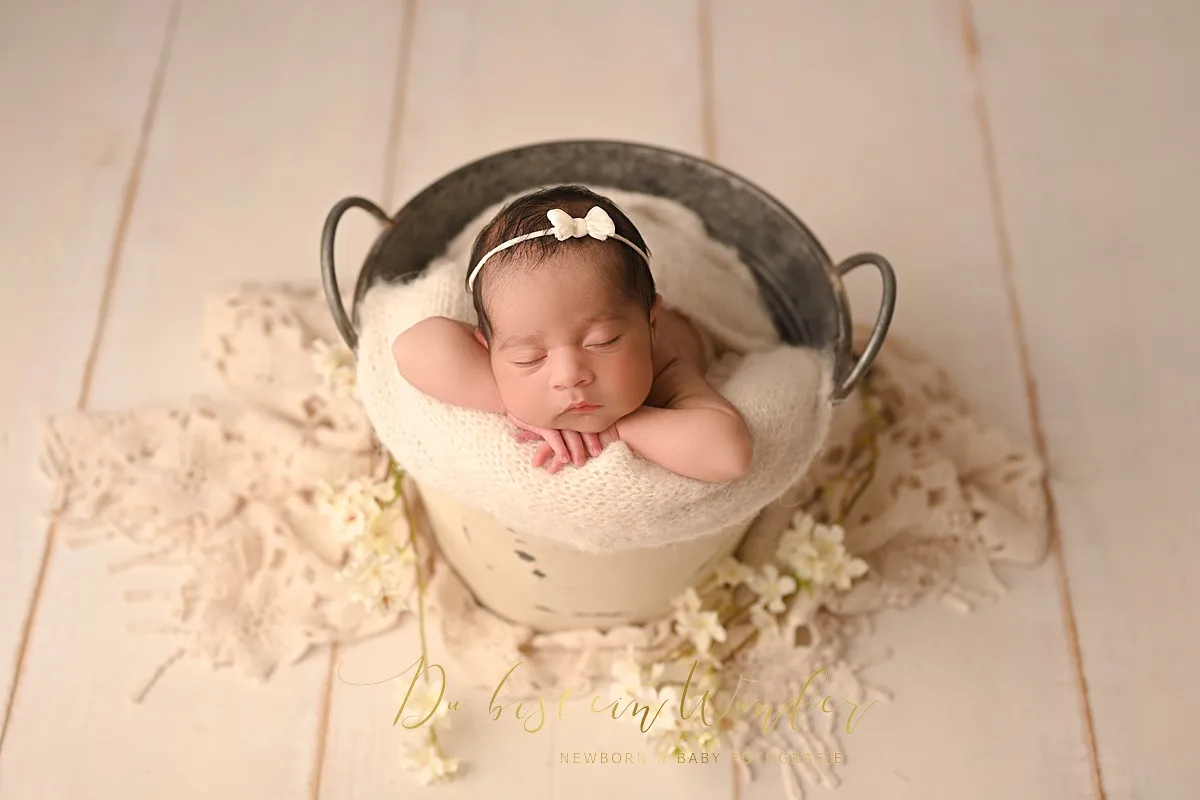 Neugeborenes Baby im Korb mit beiger Strickdecke