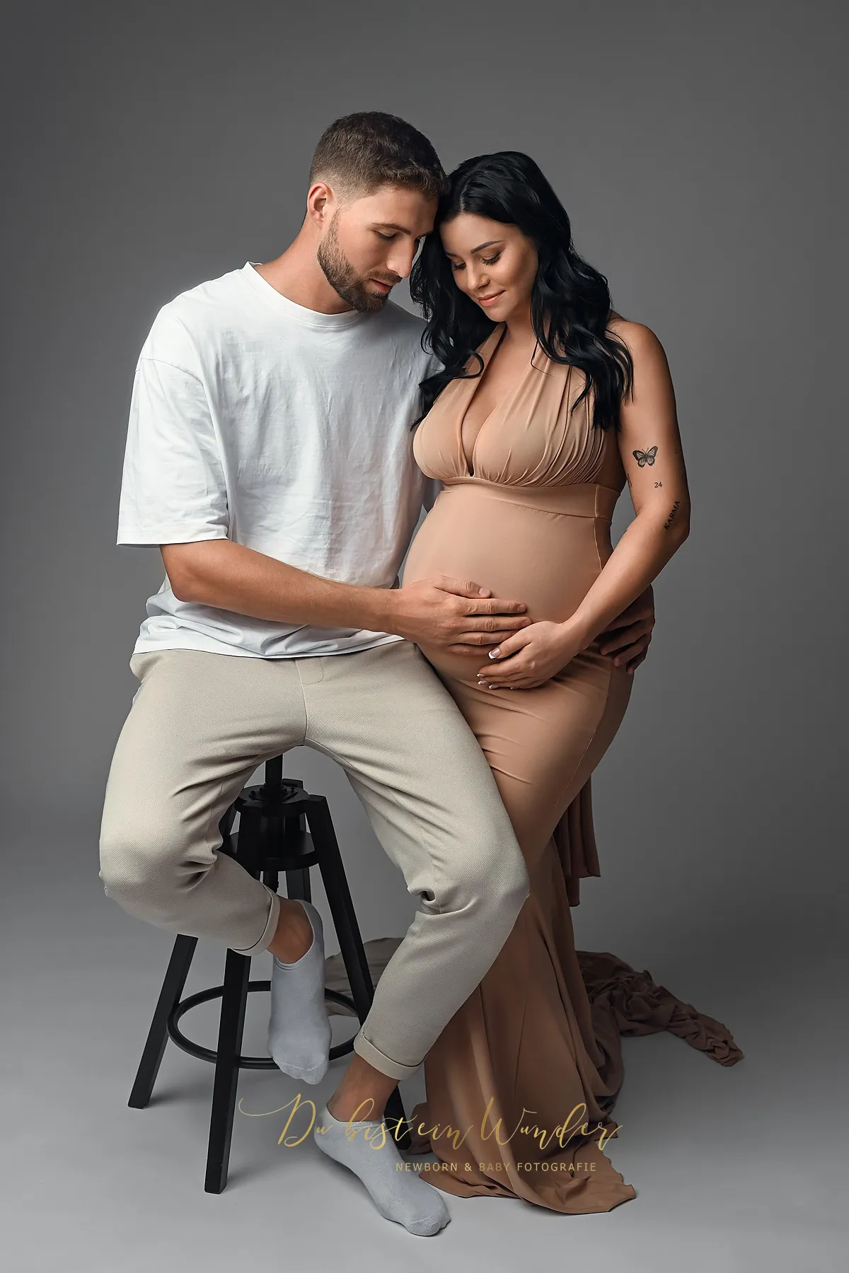 Paar beim Schwangerschaftsshooting im Studio mit beigem Kleid