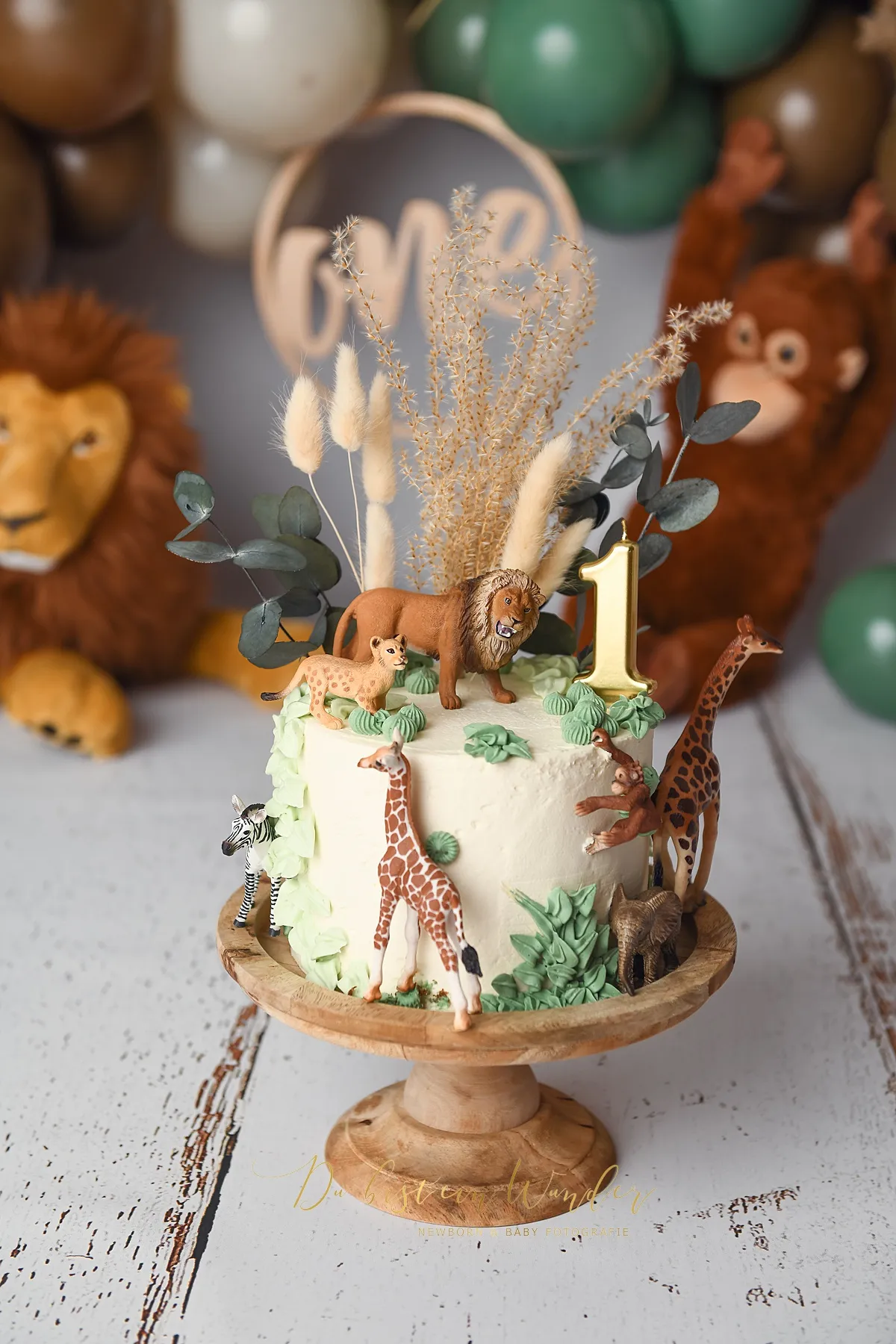 Safari-Geburtstagstorte mit Tierfiguren und Kerze zum ersten Geburtstag