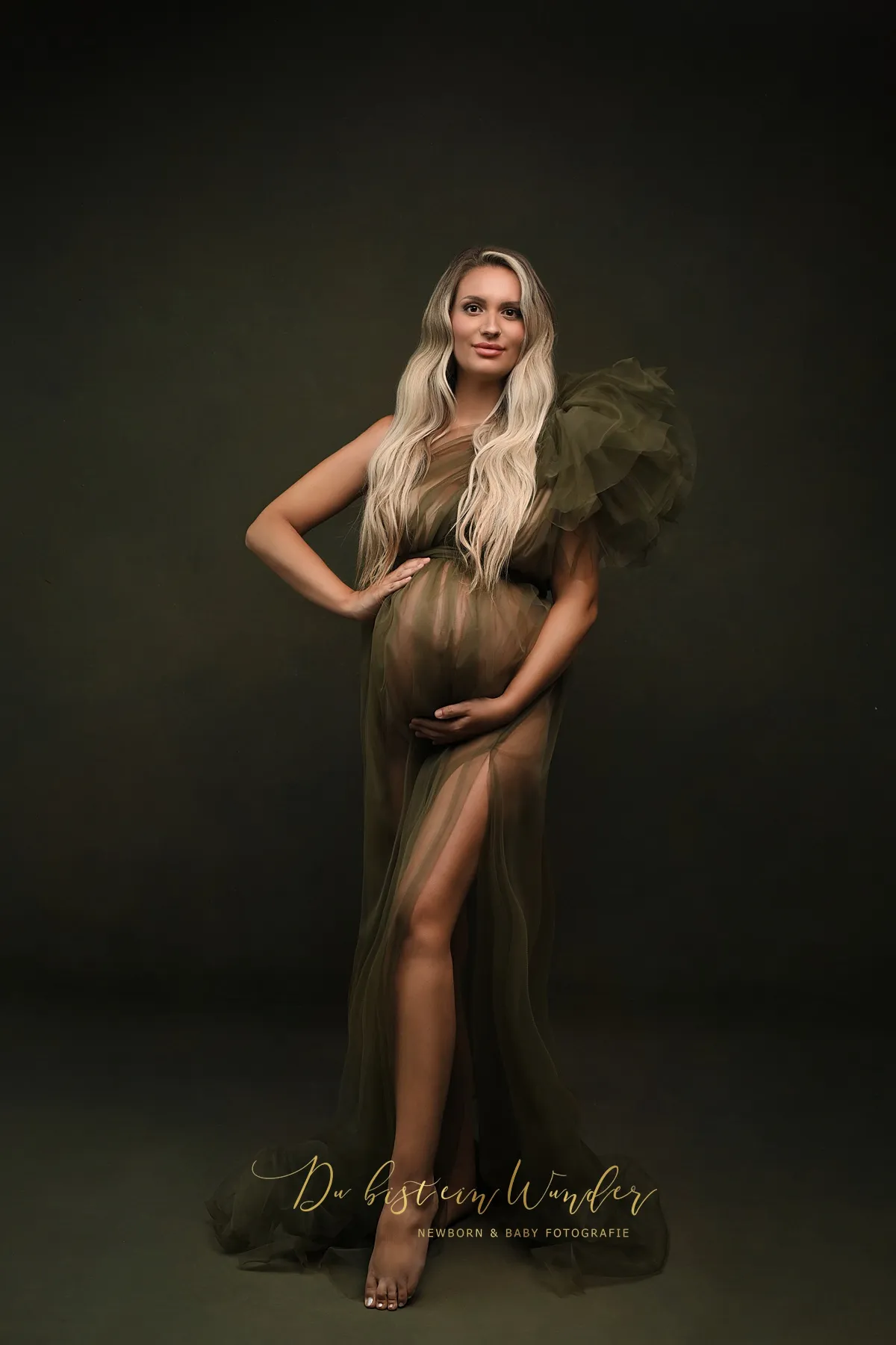 Schwangere Frau in olivgrünem Tüllkleid bei Schwangerschaftsfotografie