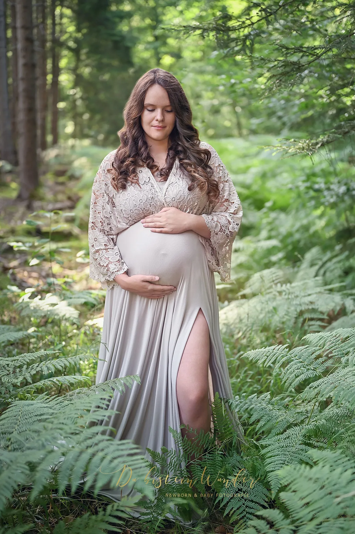 Schwangerschaftsshooting im Wald zwischen Farnen im beigen Spitzenkleid
