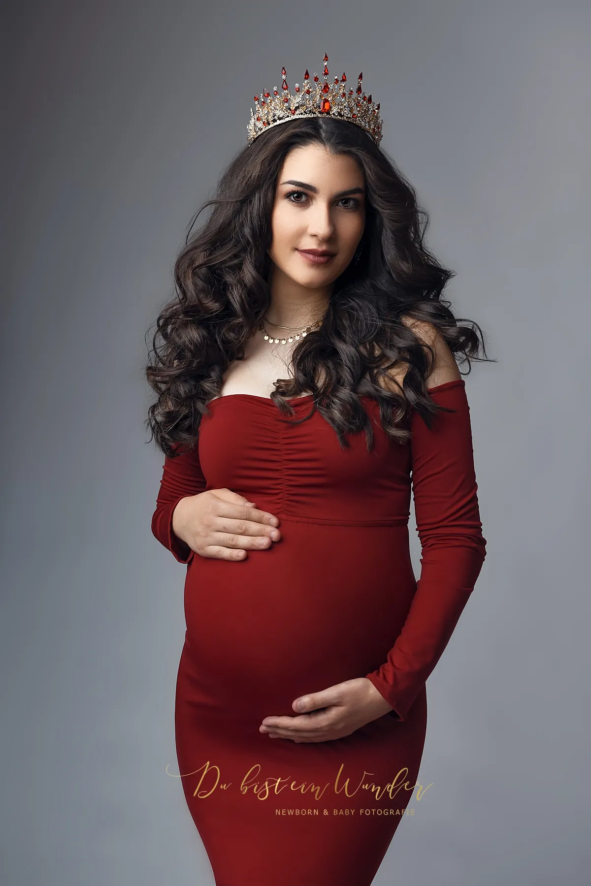 Elegantes Schwangerschaftsportrait im roten Kleid mit Krone