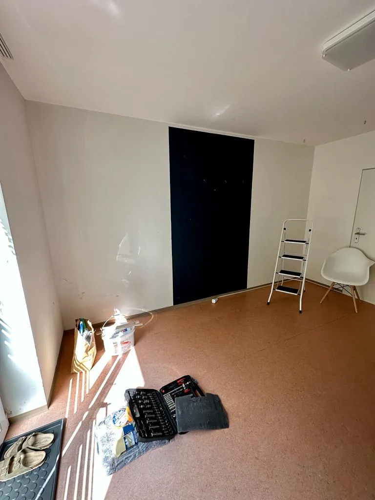 Umbauarbeiten im Showroom mit Werkzeug und Leiter vor dunkel gestrichener Wand