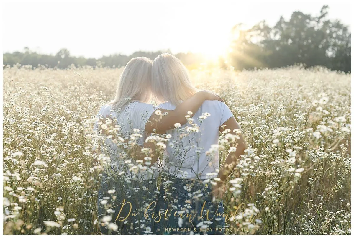 Zwei Frauen gemeinsam im Arm auf Blumenwiese