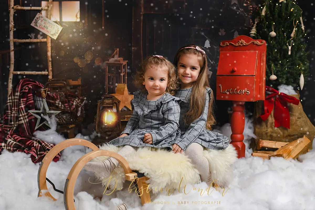 Geschwister auf Schlitten beim Weihnachtsshooting